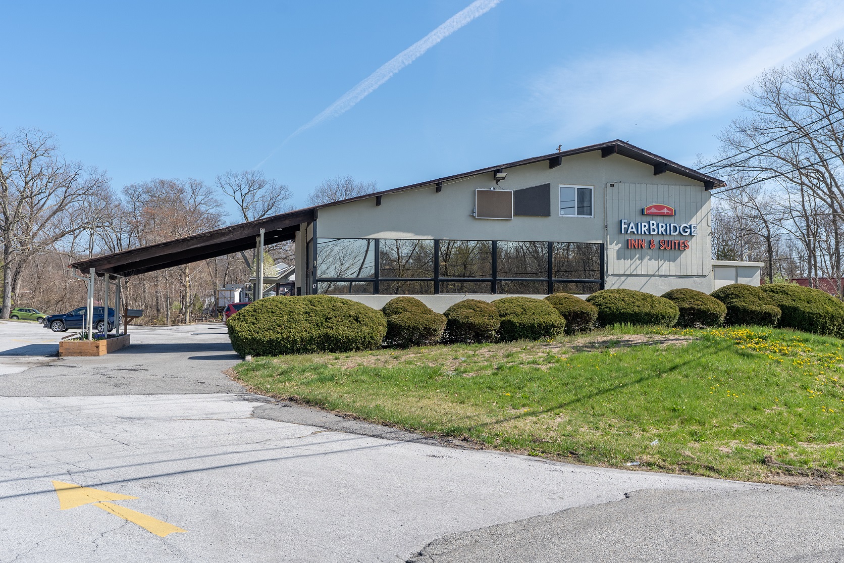 FairBridge Inn & Suites exterior under bare trees and a clear blue sky