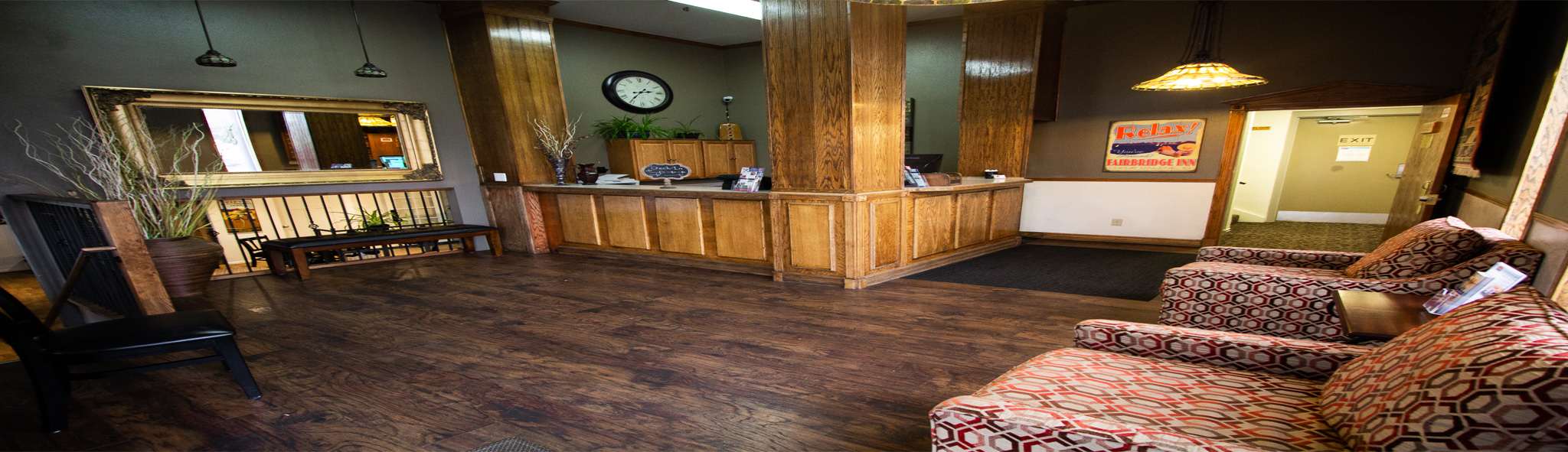 Warm wood-panelled lobby with lounge seating by the reception desk